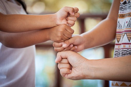 A group of happy children standing in a circle, holding hands, representing friendship and collective joy.